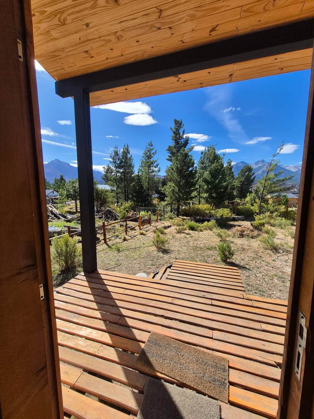 La vista desde la puerta de la cabaña hacia el deck y la montaña