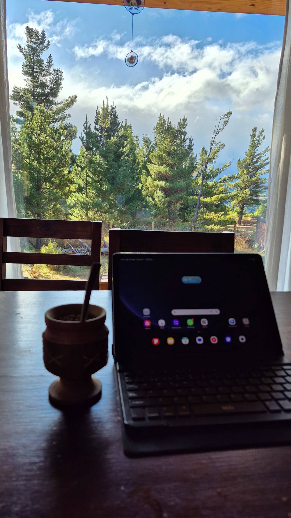 Una tablet y un mate sobre la mesa, frente a la ventana